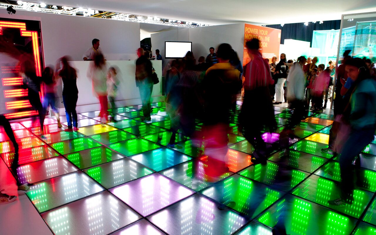 Gäste tanzen auf der leuchtenden, energieerzeugenden Tanzfläche Energydancefloor Merlin